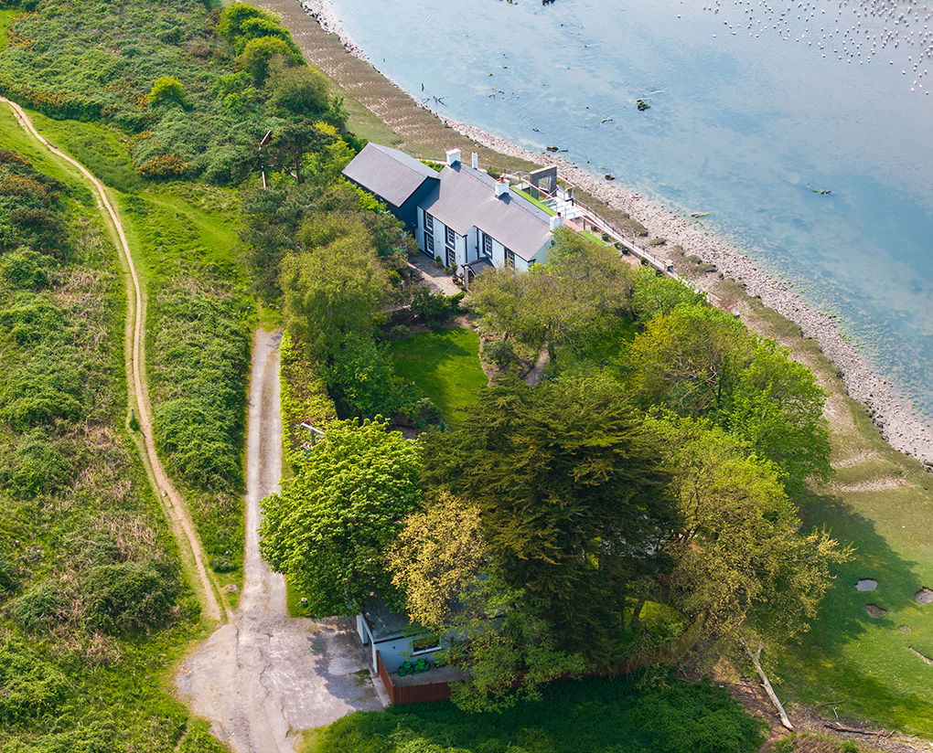 rear-view of historic building with trees and waterfront visable