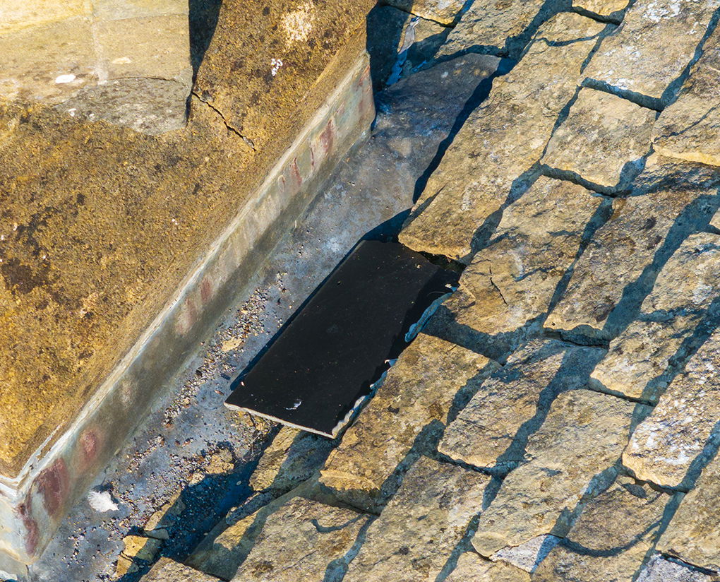 image of a damaged tile that has fallen down the side of a roof